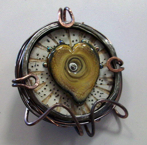 A lampwork artist uses her own heart bead for the pendant focal.
